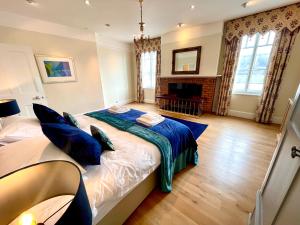 a bedroom with a large bed with blue pillows at Stunning Thameside Apartment in Henley on Thames