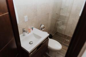 a bathroom with a toilet and a sink and a shower at Deluxe in Valledupar