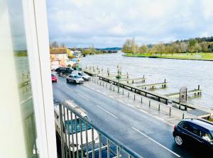 a view of a river with cars parked on a bridge at Stunning Thameside Apartment in Henley on Thames