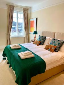 um quarto com uma cama com duas toalhas em Stunning Thameside Apartment em Henley on Thames
