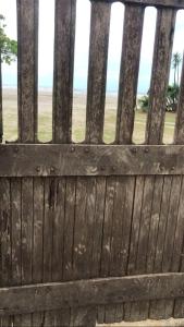 a wooden fence with the beach in the background at Camping beira mar in Bertioga