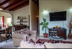 a living room with couches and a flat screen tv at Lush Green Villa with mountain and garden view in Castries