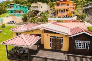 a house with a wooden deck in a village at Lush Green Villa with mountain and garden view in Castries