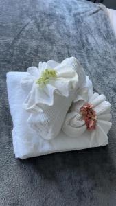 a white towel with flowers on top of it at DREAM STAY Studio in Vieux Fort