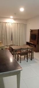 un salon avec deux tables et une télévision dans l'établissement Hillpark Residens, à Semenyih