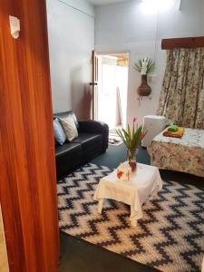 a living room with a table and a couch at Central Nadi - Lodge 2 in Nadi