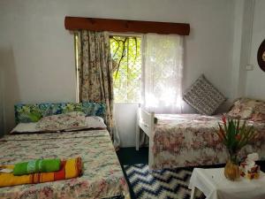 a small bedroom with two beds and a window at Central Nadi - Lodge 2 in Nadi