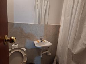 W łazience znajduje się umywalka, toaleta i lustro. w obiekcie Montañero Hostel II w mieście Huaraz