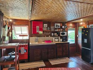 a kitchen with a red stove and a refrigerator at Studio Avea rez-de-chaussée in Parea