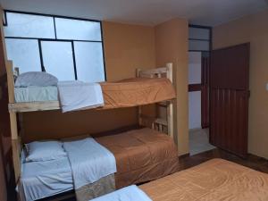 a room with two bunk beds and a window at Montañero Hostel II in Huaraz