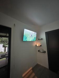 a flat screen tv on the wall of a room at Résidence Morphée Tiny House avec Jacuzzi in Montjoly