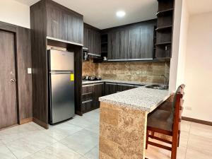 a kitchen with wooden cabinets and a stainless steel refrigerator at Katamar in Manta