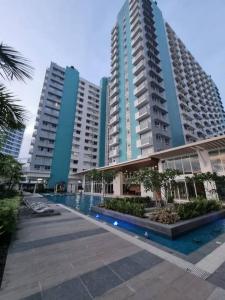 a large apartment building with a pool in front of it at The Gemini Studio in Bacolod