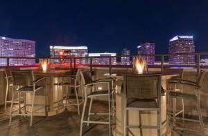 eine Bar auf der Dachterrasse mit Stühlen und Stadtblick in der Unterkunft Marriott's Grand Chateau in Las Vegas