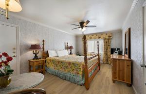 a bedroom with a bed and a ceiling fan at Carmel Inn & Suites in Carmel