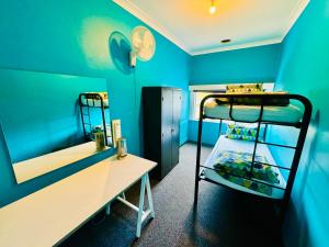 a room with two bunk beds and a desk at Crashpalace Backpackers in Rotorua