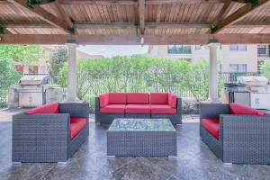a patio with two chairs and a red couch at Charming 2BD/1BA w/ Gym, Pool, BBQ Grill in Tupelo