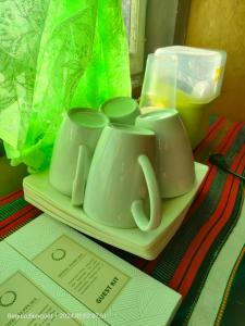 due tazze di caffè bianche su un piatto su un tavolo di Kochimoto Homestay a Baguio