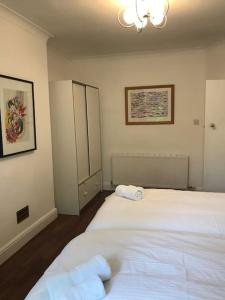 a bedroom with two white beds and a chandelier at Spacious Kosher Flat in Golders Green in London