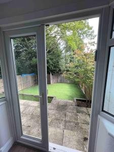 a sliding glass door with a view of a yard at Spacious Kosher Flat in Golders Green in London