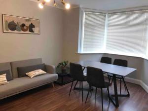 a living room with a table and chairs and a couch at Spacious Kosher Flat in Golders Green in London
