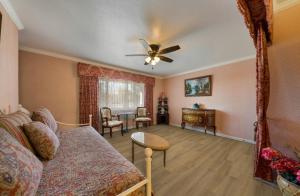 Carmel Inn & Suites في كرمل: غرفة معيشة مع أريكة ومروحة سقف