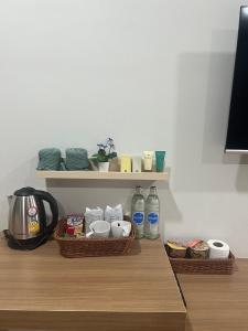 two baskets on a shelf with food and water bottles at ดิ อัยย์ชญา โฮเทล in Ban Phraek Sa