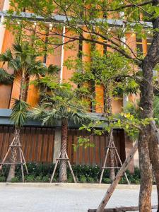 um grupo de tripé árvores em frente a um edifício em ดิ อัยย์ชญา โฮเทล em Ban Phraek Sa