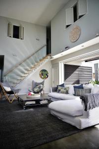- un salon avec un canapé blanc et un escalier dans l'établissement Getaway Bach Whangapoua, à Coromandel