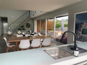 a kitchen and living room with a table and chairs at Getaway Bach Whangapoua in Coromandel Town