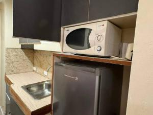 a microwave sitting on top of a refrigerator in a kitchen at Citadel Inn a1 Central Makati Nightlife in Manila