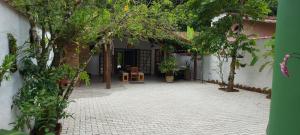 Zugang zu einem Innenhof mit Bäumen und einem Gebäude in der Unterkunft Casa Canto Verde Camburi in Camburi
