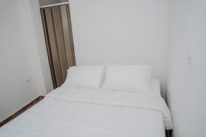 a bed with white sheets in a room at Comfort in Valledupar