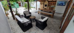 eine Terrasse mit Stühlen, einem Tisch und einer Bank in der Unterkunft Casa Canto Verde Camburi in Camburi