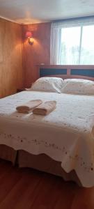 1 dormitorio con 2 camas con sábanas blancas y ventana en Apartamentos Cadiz -Valdivia, en Valdivia