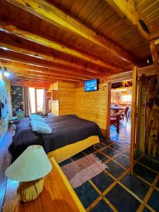 1 dormitorio con 1 cama grande en una cabaña de madera en Cabañas Casa de Piedra en Trevelín
