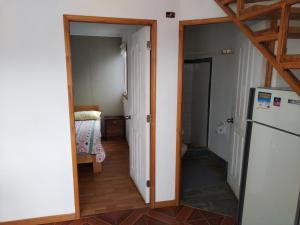un couloir avec un réfrigérateur et une chambre avec un lit dans l'établissement Costa Margarita, à El Tabo