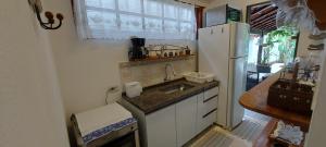 eine kleine Küche mit Spüle und Kühlschrank in der Unterkunft Casa Canto Verde Camburi in Camburi