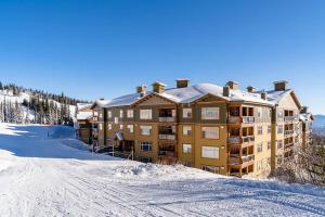 un gran edificio con nieve encima en The Aspens 5 w/ Hot Tub, en Big White