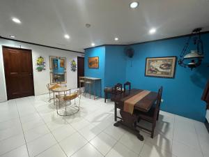 ビガンにあるCasa De Soledad Vigan Cityの青い壁の客室で、テーブルと椅子が備わります。