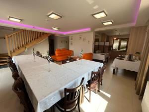 Snochowice的住宿－Leśny Dworek，一间用餐室,配有一张白色的大桌子和椅子