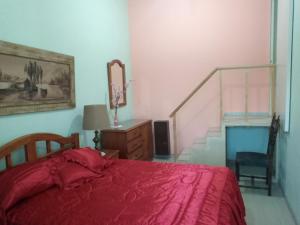 1 dormitorio con cama roja y escalera en Sai Ram en San Martín