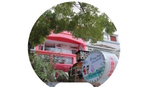 a mirror image of a pink building with a tree at Qing Noise Villas in Hualien City