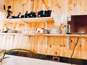 eine Küche mit Holzwänden und Regalen mit Töpfen und Pfannen in der Unterkunft Arriendo Cabaña Entre Arrayanes. in Las Quemas del Salto