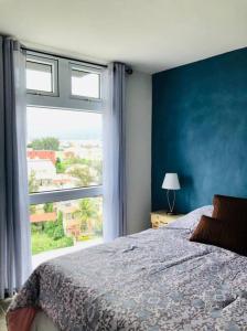 - une chambre avec un lit et une grande fenêtre dans l'établissement Exclusive Apartment, Calzada Roosevelt, à Guatemala