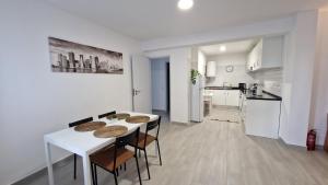 uma cozinha e sala de jantar com uma mesa branca e cadeiras em Apartamento Cristino na Praia da Luz