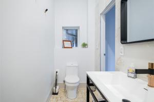 トロントにあるQueen Loft in Natureのトイレと洗面台を備えた白いバスルーム +12枚の写真