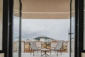 balcone con sedie, tavolo e vista di POETICA BOUTIQUE SKY HOTEL a Napoli