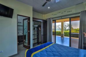 una camera con un letto blu e giallo e un balcone di Ojochal Magnificent Ocean View a Ojochal Altre 30 foto