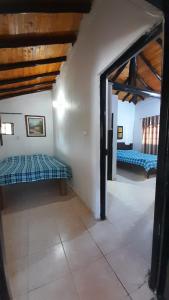 1 dormitorio con 2 camas en una habitación en HOSPEDAJE CAMPESTRE VILLA PARAISO en Curití